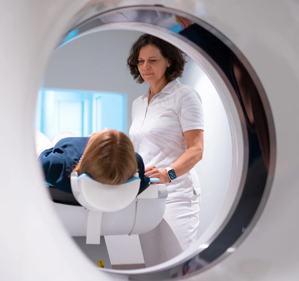 Frau Dr. Garmer steht neben einer Patientin vor eine Kardio CT.