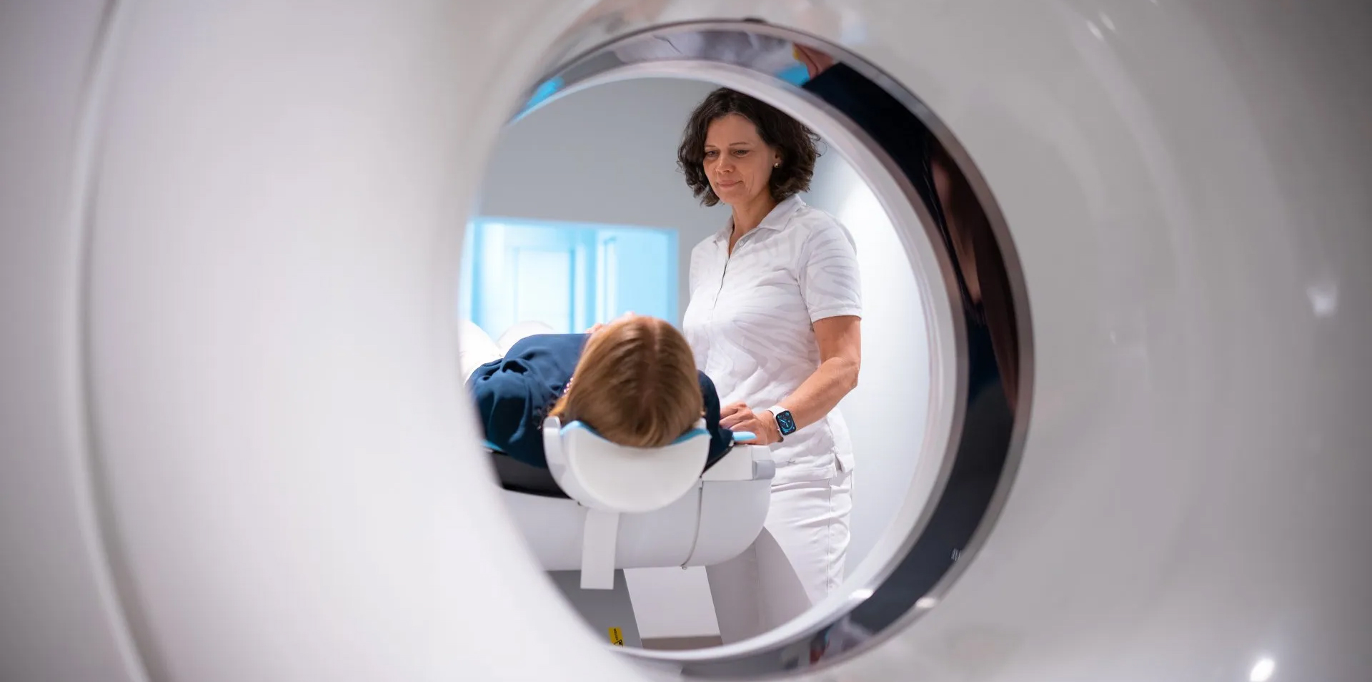 kardio ct radiologie Frau Dr. Garmer steht an der CT-Röhre und schaut auf ihre Patientin.